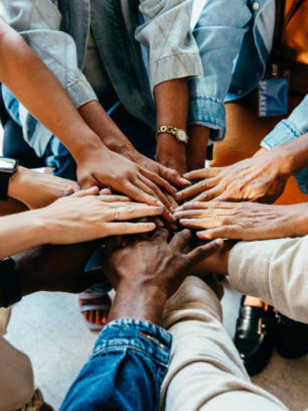 Diverse group of hands joined together, representing teamwork and unity. Symbolizes cooperation, collaboration, and the power of collective effort.